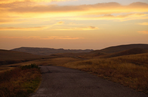 Hermosa vista al atardecer del desierto de la carretera rural entre los campos de otoño amarillo en la hora de la noche. Desierto en el sur de Georgia
 - Foto, Imagen