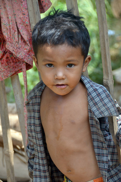 PHNOM PHEN, CAMBODIA - maaliskuu 23: Tunnistamaton katulapsi poseeraa 23 maaliskuu 2013 Phnom Phen, Cambodia.Pelkästään Phnom Penh on välillä 10,000 ja 20000 lasta elää ja työskentelee kaduilla  - Valokuva, kuva