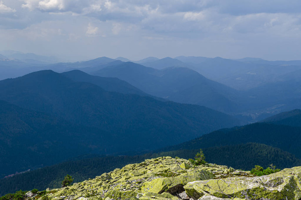 Sıradışı dağ yürüyüşleri. Sisteki yüksek sıradağların zeminine karşı yeşil oklarla kaplanmış devasa taşlar. - Fotoğraf, Görsel