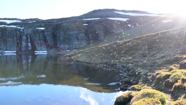 Many mosquitoes flying over an alpine lake. Slow motion video. Lake is located near the  national tourist snow road Aurlandsvegen (f243) hat is runs across the mountains. Norway. - Footage, Video
