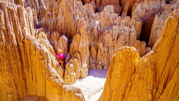 Senior Woman wandelen door de Slot Canyons en Hoodoos veroorzaakt door erosie van de zachte vulkanische Bentoniet Clay in Cathedral Gorge State Park in de Nevada woestijn, Verenigde Staten - Foto, afbeelding