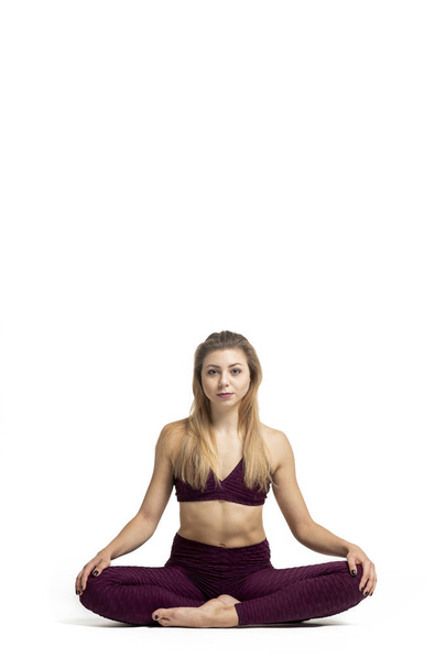 blonde girl doing gymnastic stretching dressed in sportswear with white background - Foto, afbeelding