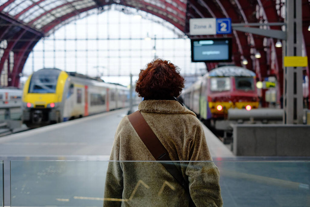 Rear view of a woman standing on station platform - Foto, Imagen