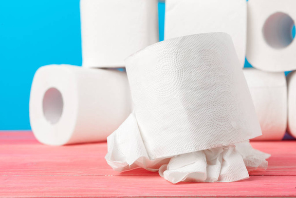 Toilet paper rolls stacked against blue background - Foto, afbeelding