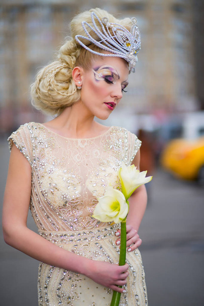 Chica con un maquillaje original en un hermoso vestido con flores
. - Foto, imagen