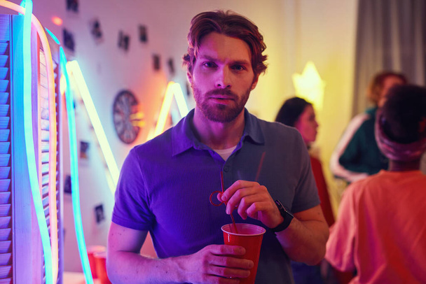 Mies cocktailin kanssa juhlissa
 - Valokuva, kuva