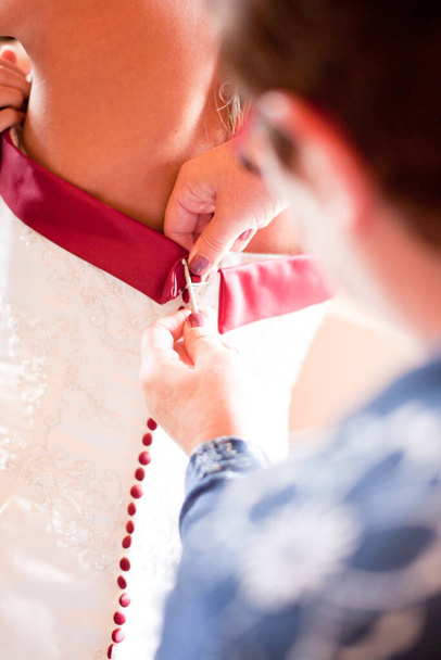  Ayudar a la novia a ponerse su vestido de novia
  - Foto, Imagen