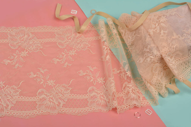 Delicate color laces for panties and bras on pink and blue background with plastic fittings. Elastic material. Using for Atelier and fabric store. - Photo, Image