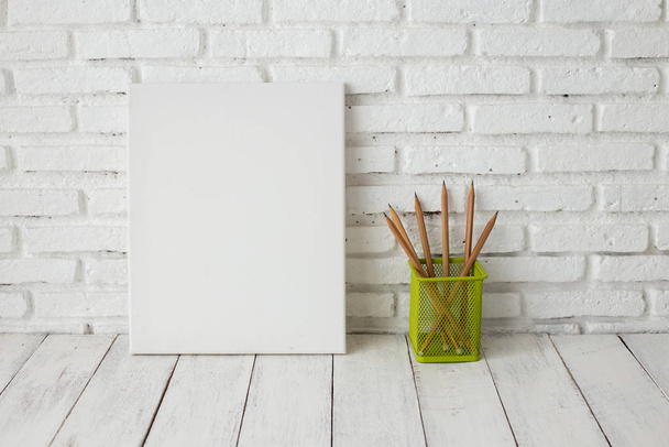 Empty white canvas frame on a wooden table - Fotó, kép
