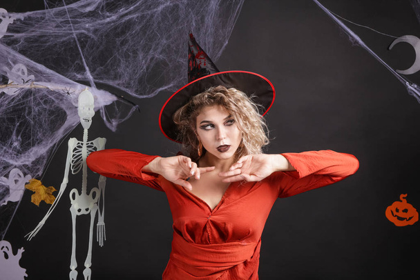 Belle femme habillée en sorcière pour Halloween sur fond sombre - Photo, image