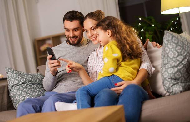 happy family with smartphone at home at night - Foto, imagen