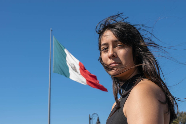 portret van mooi mexicaans meisje met mexicaanse vlag op de achtergrond - Foto, afbeelding