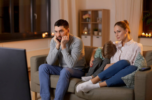 family watching something boring on tv at night - Foto, afbeelding