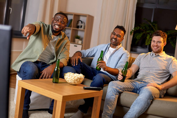 happy male friends with beer watching tv at home - Foto, Imagen