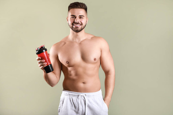 Sporty man with protein shake on color background - Foto, imagen