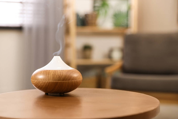 Aroma oil diffuser on wooden table at home, space for text. Air freshener - Fotografie, Obrázek