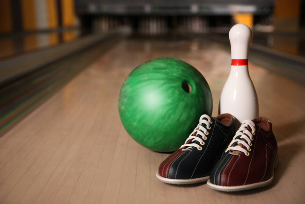 Pin, shoes and ball on alley in bowling club. Space for text - 写真・画像