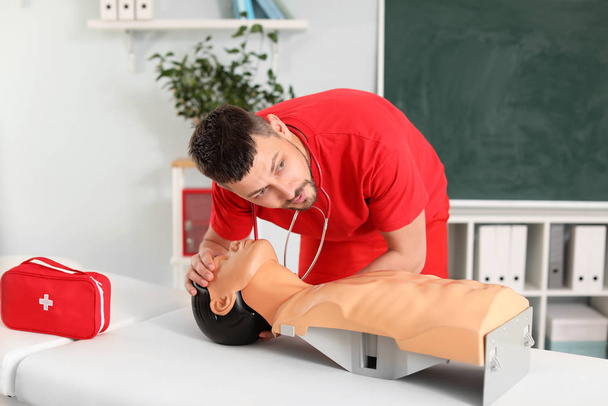 Ausbilder demonstriert bei Erste-Hilfe-Lehrgang CPR an Schaufensterpuppe - Foto, Bild