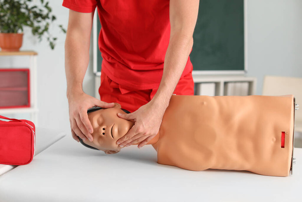 Instructor demonstrating CPR on mannequin at first aid training course - Photo, Image