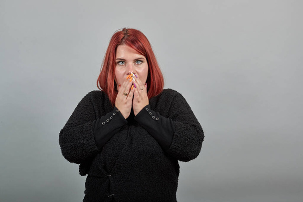 fat lady in sweater shocked woman reacts to the event, covers face with hands - Foto, Bild
