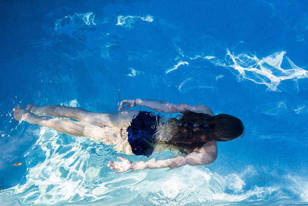 εφηβική κοπέλα που κολυμπούν σε μια πισίνα, θέα από ψηλά. - Φωτογραφία, εικόνα