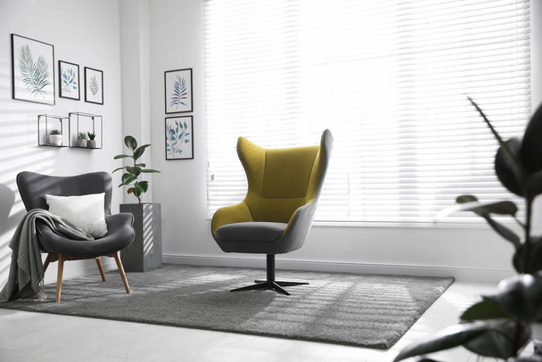 Comfortable armchairs near window in light room - Foto, Bild