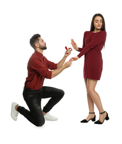 Young woman rejecting engagement ring from boyfriend on white background - Φωτογραφία, εικόνα