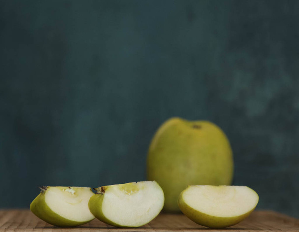  Three apple slices on the background of a whole large fruit - Foto, afbeelding
