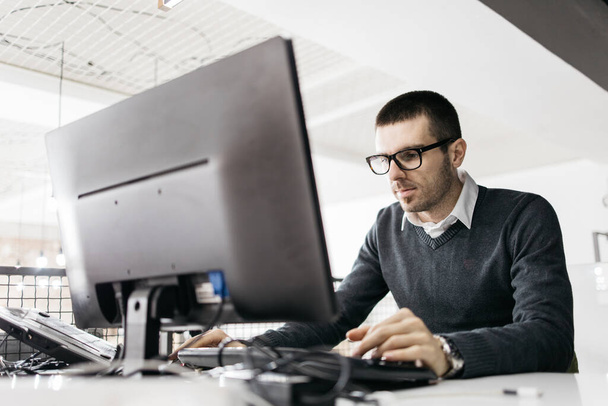 Konzentrierter Mann arbeitet im Büro am Computer - Foto, Bild