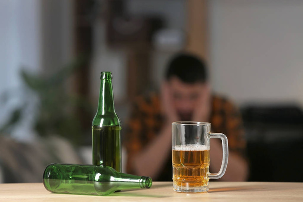 Butelki i kubek piwa na stole. Pojęcie alkoholizmu - Zdjęcie, obraz