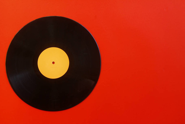 Vinyl record on a red background. Retro style. Top view. - Photo, Image