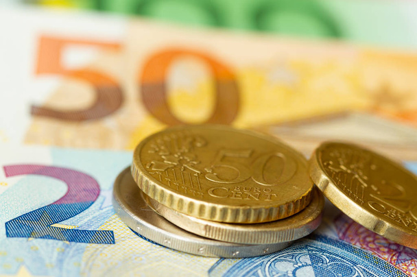 Diferentes monedas en euros sobre un fondo de billetes
 - Foto, Imagen