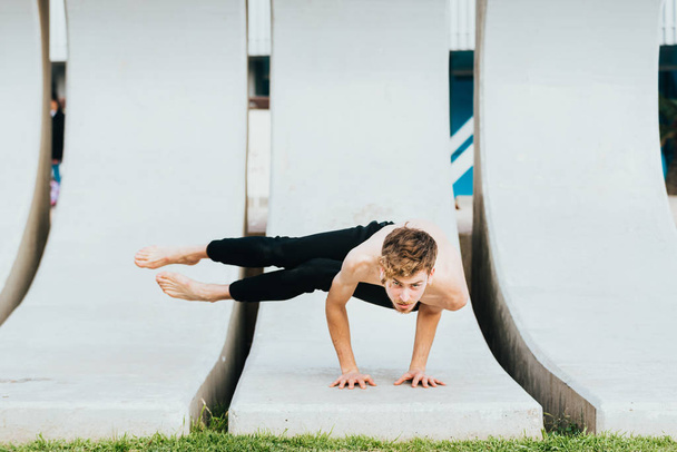 astakrasana, een achthoekige yoga asana ter versterking van de onderarmen getraind door een jonge mannelijke atleet. - Foto, afbeelding
