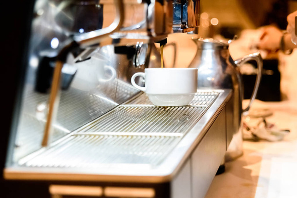 Cafetera preparando un espresso para el desayuno de los clientes en una cafetería europea. - Foto, imagen