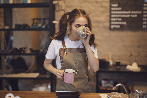 Barista woman testing taste of brewed coffee in the cafeteria - 写真・画像