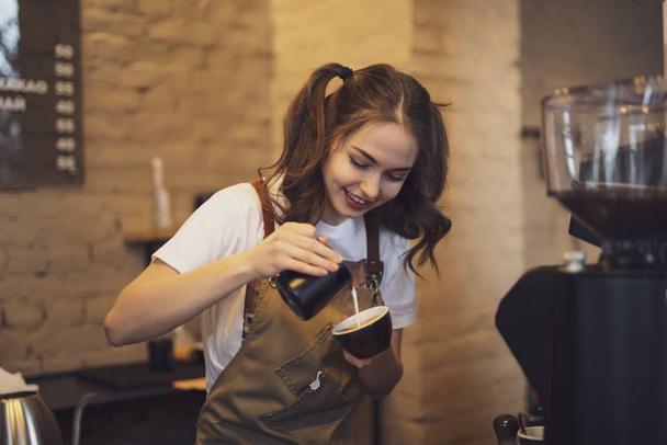 Barista woman make a coffee in the cafeteria - 写真・画像