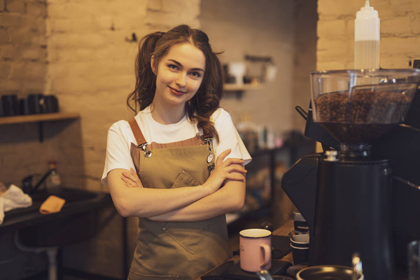 Portrait of young barista woman with crossed arms - Foto, Imagem