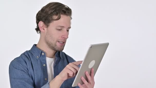 Szczęśliwy młody człowiek za pomocą cyfrowego tabletu na białym tle - Materiał filmowy, wideo