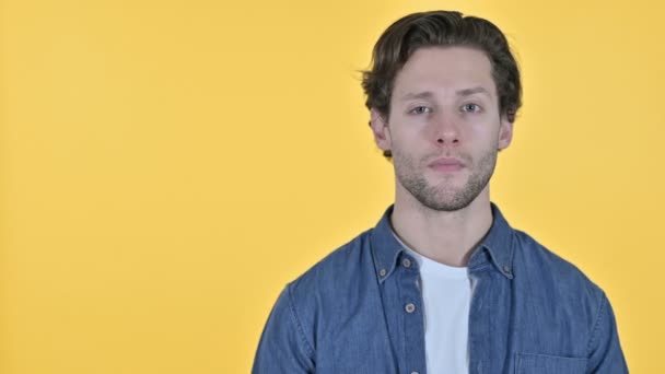Young Man Holding Hand Out, Τοποθέτηση προϊόντος σε κίτρινο φόντο - Πλάνα, βίντεο