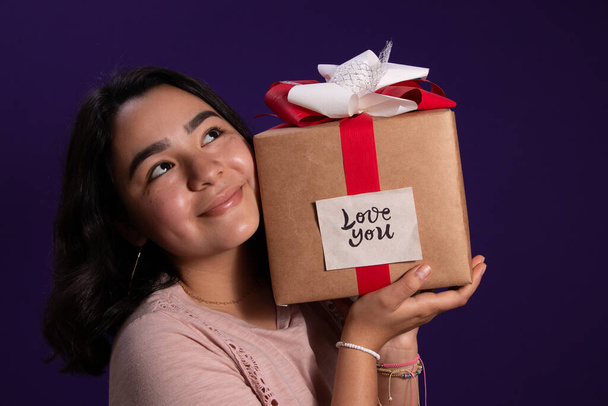 Giovane e felice ragazza latina che riceve un regalo d'amore
 - Foto, immagini