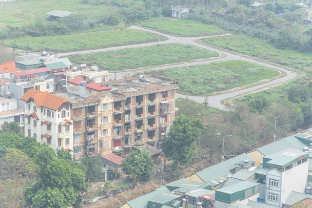 Zupełnie nowe i w budowie wielopiętrowe domy na przedmieściach Hanoi, Wietnam. Widok z lotu ptaka miejskiego z zielonym metalowym dachem domów. Dostępne wielkości partii po lewej stronie. - Zdjęcie, obraz