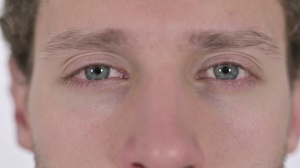 Nahaufnahme der blinkenden Augen eines jungen Mannes auf weißem Hintergrund - Filmmaterial, Video