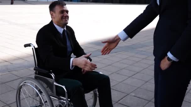 Zakenvrouw schudden handen met een handicap zakenman outdoor - Video