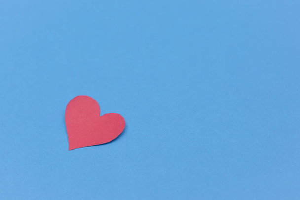 Red paper broken heart on blue background - Fotografie, Obrázek