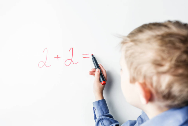 child counts on the blackboard with a marker - Fotoğraf, Görsel