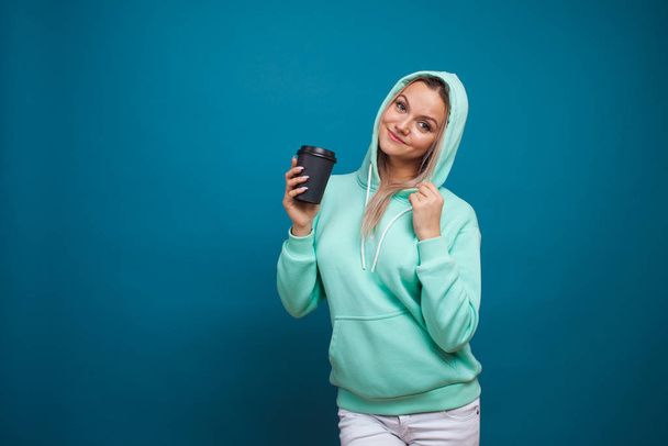 Warming drinks for autumn and winter. Stylish trendy hipster girl in a blue hoodie - Valokuva, kuva