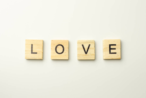 Text wooden blocks spelling the word LOVE on white background - Foto, imagen