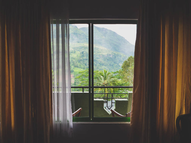 Immagine tonica di guardare attraverso la finestra della villa sulla foresta tropicale della giungla e sui pendii montani dello Sri Lanka
 - Foto, immagini