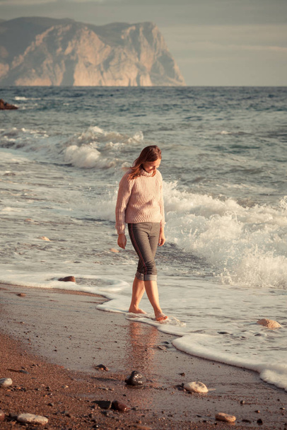 美しい幸せな女性は素足で海岸を歩く。、屋外 - 写真・画像