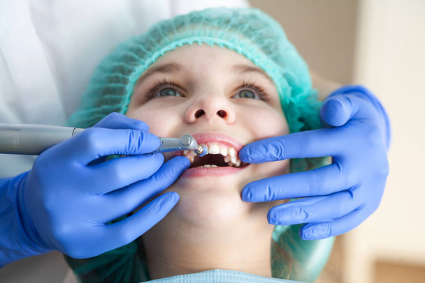 Tyttö hammaslääkärin vastaanotolla. Suuontelon ja hampaiden tarkastus lapsessa
. - Valokuva, kuva